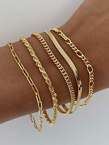 Five gold chain bracelets on a wrist